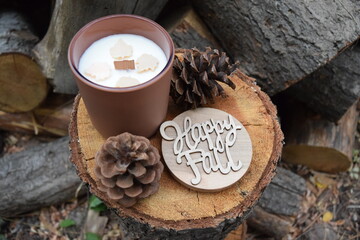 Happy Fall wood wick candle with pinecones on wooden log. 