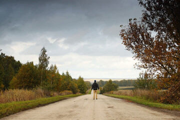 Man on empty road and autumn nature around and grey sky. Pavel Kubarkov, i on empty road. Photo was taken 1 October 2022 year, MSK time in Russia. - 536840615