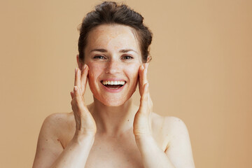 smiling modern 40 years old woman with face scrub