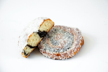 Yeast dough bun with poppy seeds with sprinkles on a white background