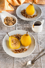 Delicious homemade autumn dessert: pears boiled in white wine. Pears in white wine with caramel on a light marble table. Light fruit dessert.