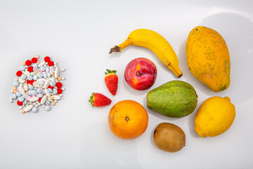 a handful of pills next to a bunch of fresh berries