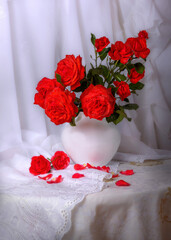 bouquet of red roses in a white vase on a white background