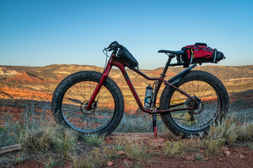 Fototapeta na wymiar fat mountain bike with a frame and trunk bag during biking trip at foothills of Colorado, fall scenery in Red Mountain Open Space