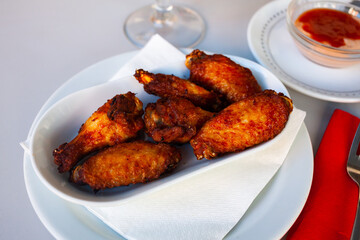 Appetizing crispy deep fried chicken wings served on plate. Popular snack