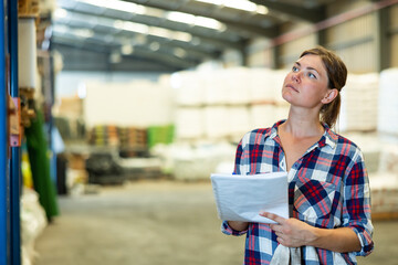 Woman supervisor checking quality of production at hardware store warehouse