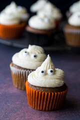 Pumpkin spice cupcakes with ghost shaped icing tops and eyeballs.