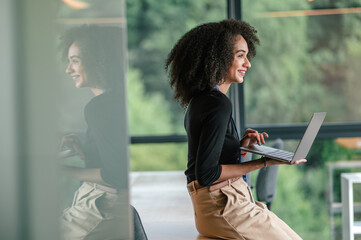 Dark-haired cute young woman with a alptop in the office
