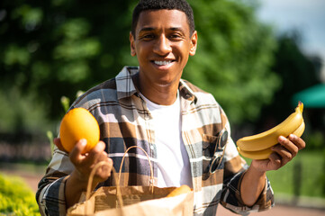 Young man with a paper bag after food shopping