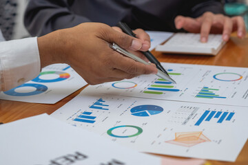 The company's team of marketers analyzes the company's profits using laptop computer graphs and calculators.