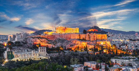 Fototapeta premium Night view at historical center of Athens, Greece. Artistic postproduction with dramatic sky over old ancient European city, touristic iconic destination. View at Acropolis building and Agora mountain