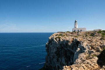 Faro de Cavalleria con mar azul en calma y cielo despejado en isla de menorca