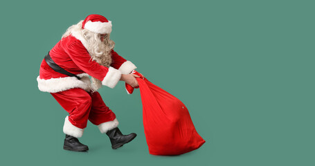 Santa Claus with heavy bag on green background with space for text