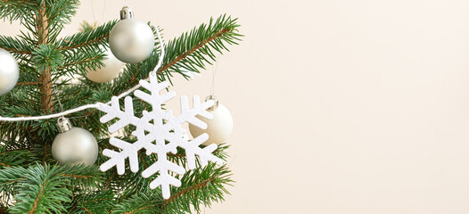 Beautiful Christmas tree decorated with snowflakes and balls on light background, closeup. Banner for design