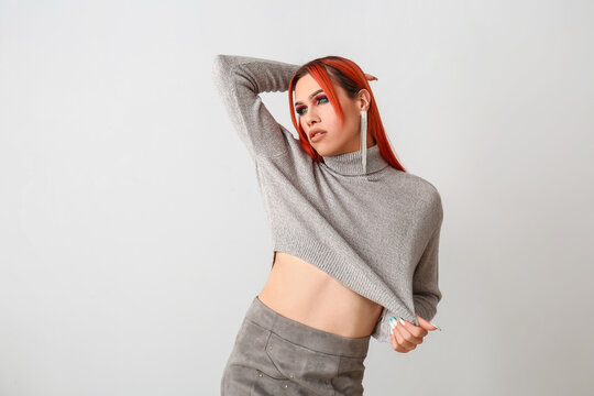 Stylish transgender woman on light background