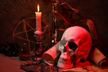 Scull, burning candle and magic attributes for ritual on grunge background
