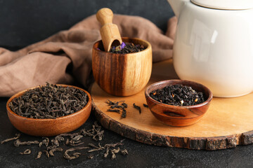 Bowls with dry tea leaves on dark table