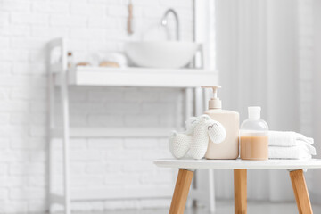 Different bath supplies for children and toys on white table in light bathroom