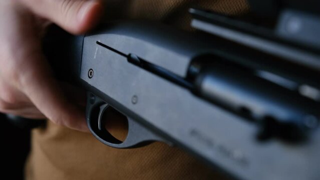 Close Up Of Inspecting Rifle. finger releases the safety on the shotgun and imitates a close-up shot. trigger guard release. with inscription on gun SPECIAL PURPOSE