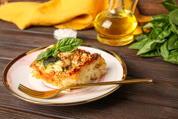 Plate of tasty Italian pie with mozzarella and pesto sauce on wooden table