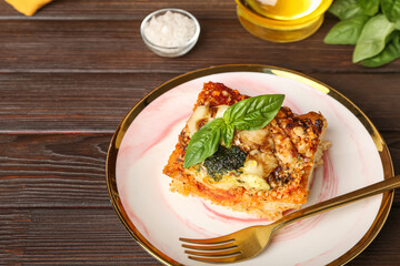 Plate of tasty Italian pie with mozzarella and pesto sauce on wooden table, closeup