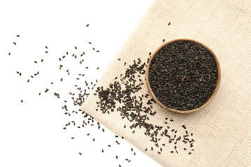 Bowl of black sesame seeds on white background