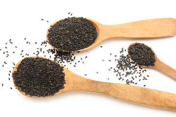 Wooden spoons with black sesame seeds on white background, closeup