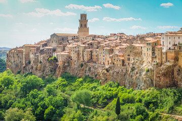 Pitigliano wall and cityscape above hills and cypresses, Tuscany, Italy