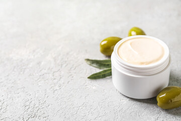 Obraz na płótnie Canvas Jar of natural olive cream on light background