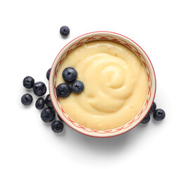 Bowl of tasty vanilla pudding with blueberry on white background