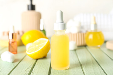Bottle of citrus serum on color wooden table