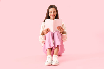 Beautiful woman reading book on pink background