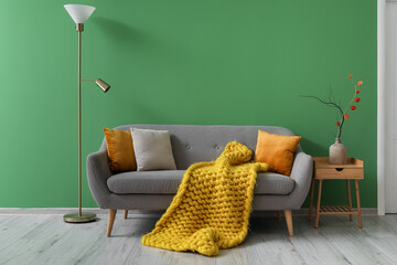 Autumn interior of living room with grey sofa, table and lamp