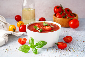 Bowl with delicious tomato soup on light background