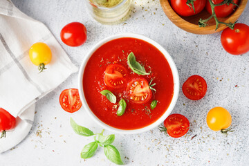 Bowl with delicious tomato soup on light background