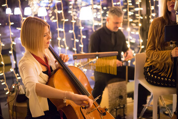 Musical band playing on the small concert stage in the restaurant at night