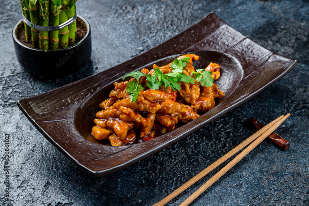 Sticker pork in sweet and sour sauce on dark stone table, chinese cuisine