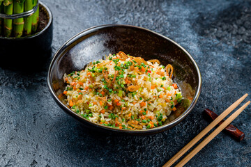 Rice with vegetables on dark stone table