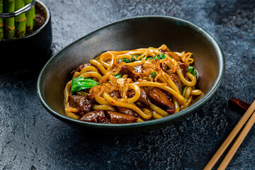 fried Udon with beef and vegetables on dark stone table - 536861069