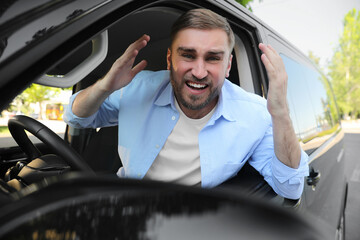 Emotional man in car. Aggressive driving behavior