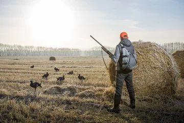 Fototapeten Hunter with a gun hunting on birds in autumn season. Male hobby concept. © Sergey