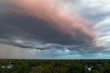 Dark stormy clouds forming on gloomy sky before heavy rainfall over suburban town area