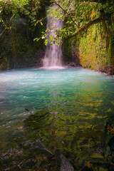 Fototapeta na wymiar Curug Cipondok of Subang west Java Indonesia. Jungle waterfall cascade in tropical rainforest with rock and turquoise blue pond. 