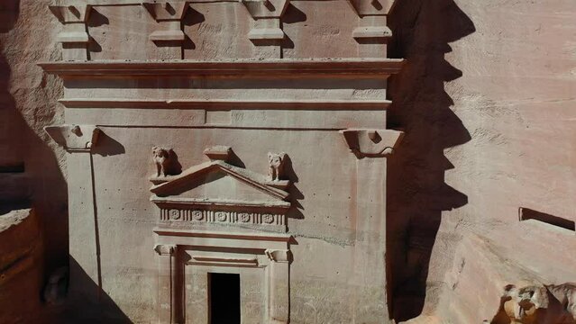 Aerial view away from a Tomb at Al-Hijr, Hegra, Madain Salih in sunny Saudi Arabia - pull back, drone shot