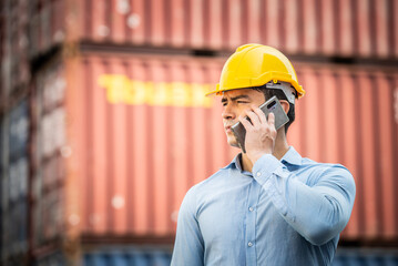 Caucasian worker use smartphone and tablet about business working at the port for transfer products.