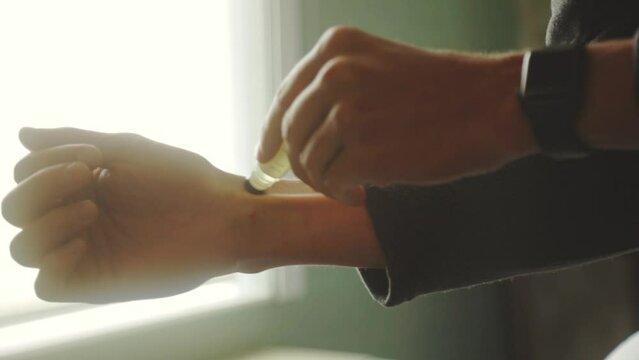 Man Applying Roll-On Perfume On His Wrist. Close Up
