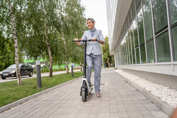 Obraz premium One woman mature senior adult female with eco electric kick scooter