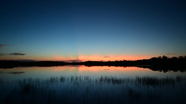 Time lapse of colorful sunrise cloudscape with bright sun rays over Nine Mile Pond in Everglades National Park, Florida 4K..