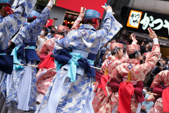 Ikebukuro, Tokyo / Japan - October 8 2022: Crowd of Yosakoi dancers wearing blue and red costumes performing in the streets during Tokyo Yosakoi festival.