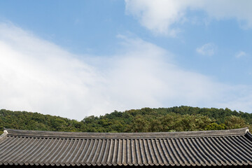 Clouds over the mountains on a nice day. Korean traditional roof under it